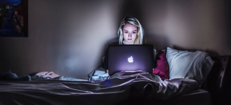 Girl with her laptop in a dark room.